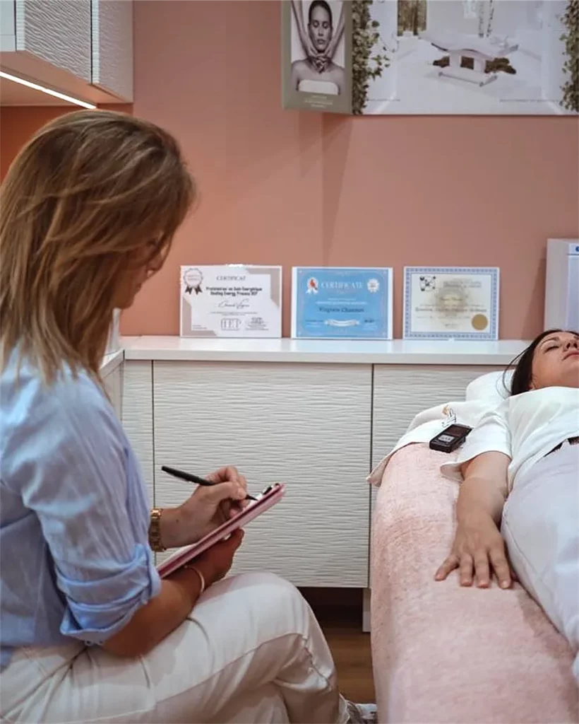 Séance d’hypnose régressive quantique : Virginie prend des notes à côté d’une cliente allongée et détendue